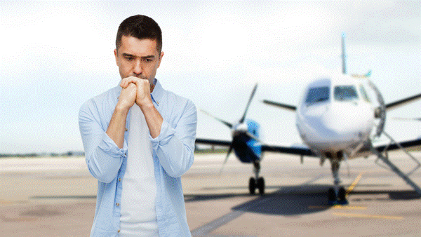 Fearful man standing on tarmac with aircraft in background