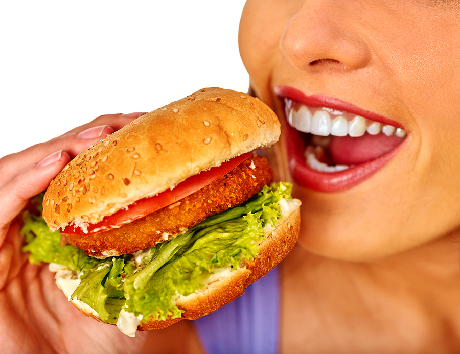Girl eats big hamburger fast food. Fastfood concept. Girl eats big hamburger fast food. Fastfood concept.