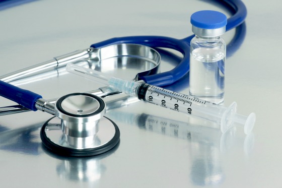 Syringe, vial and stethoscope on surgical tray.