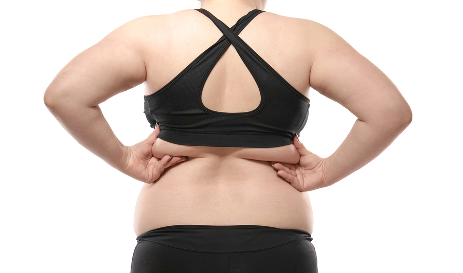 Woman touching fat on her back against white background. Weight